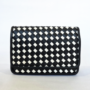 Pre-loved black and white woven checkerboard flap bag with solid black trim and accordion sides.